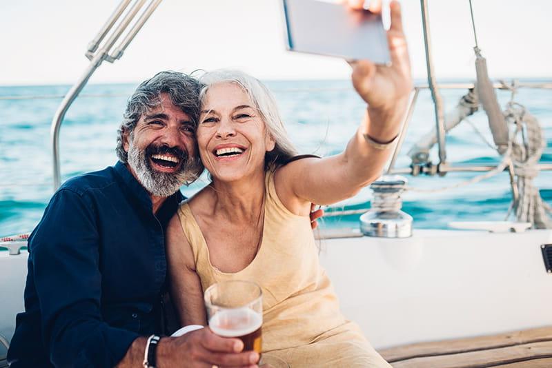 happy couple on sailboat taking selfie