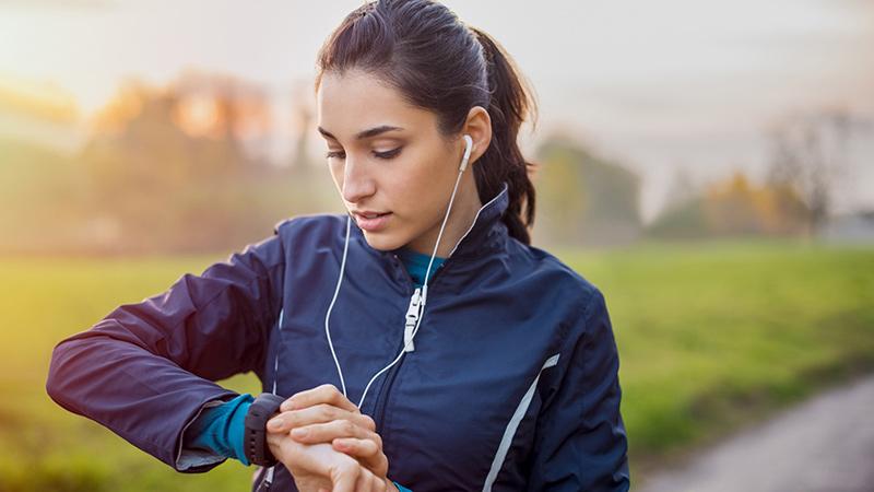Woman outdoors working out looking at watch